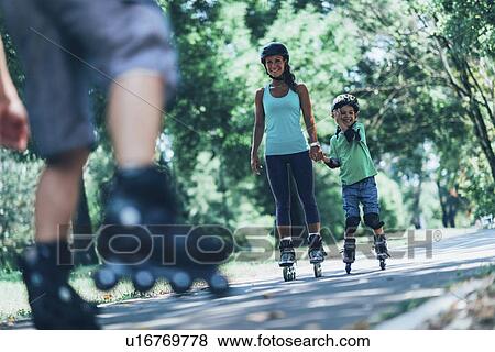 Stock Photo - Family roller skating in park. Fotosearch