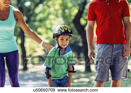 Stock Photo - Family roller skating in park. Fotosearch