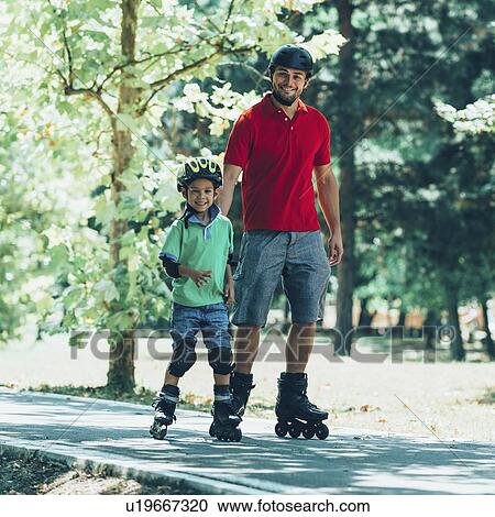 Stock Image - Father teaching son to roller skate in park. Fotosearch