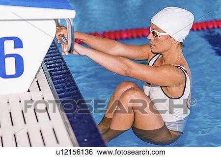 Stock Photograph - Female swimmer on starting block. Fotosearch