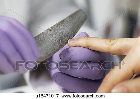 Stock Photo - Filing fingernails at nail salon. Fotosearch