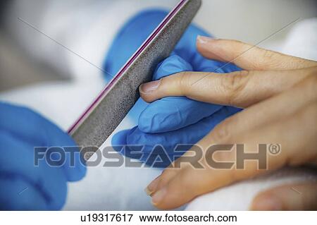 Stock Photo - Filing fingernails at nail salon. Fotosearch