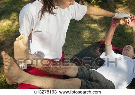 Stock Image - First aid treatment of leg. Fotosearch