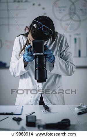 Picture - Forensics expert examining crime scene evidence. Fotosearch