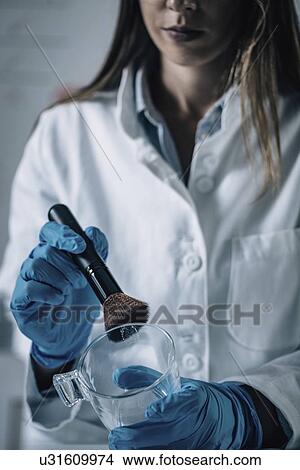 Picture - Forensics expert examining crime scene evidence. Fotosearch