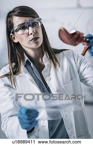 Stock Image - Forensics expert examining crime scene evidence. Fotosearch