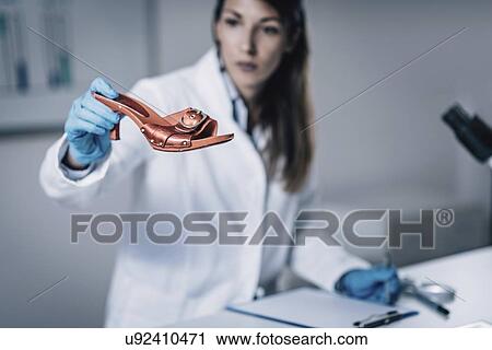 Stock Image - Forensics expert examining crime scene evidence. Fotosearch
