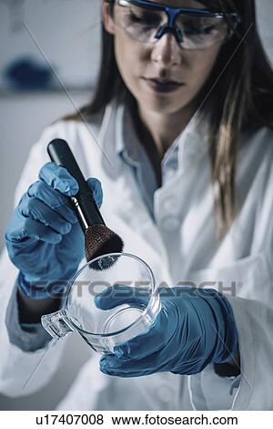 Stock Photo - Forensics expert examining crime scene evidence. Fotosearch