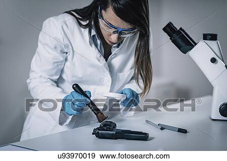 Stock Photo - Forensics expert examining crime scene evidence. Fotosearch