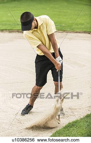 Stock Photograph - Golfer playing from bunker. Fotosearch