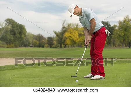 Stock Photo - Golfer putting the ball. Fotosearch