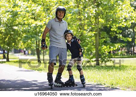 Stock Image - Grandfather and grandson roller skating. Fotosearch
