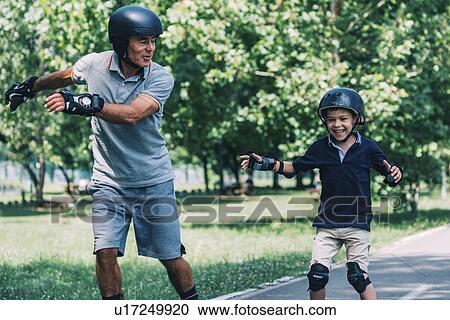 Stock Image - Grandfather and grandson roller skating. Fotosearch