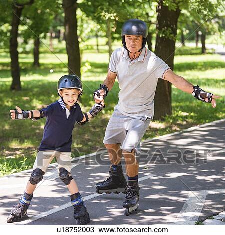 Stock Image - Grandfather and grandson roller skating. Fotosearch