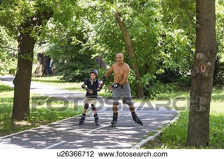 Stock Image - Grandfather and grandson roller skating. Fotosearch