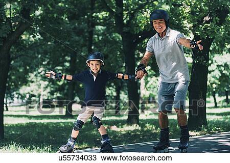 Stock Image - Grandfather and grandson roller skating. Fotosearch