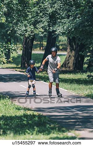 Stock Photo - Grandfather and grandson roller skating. Fotosearch