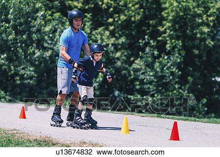 Stock Image - Grandfather teaching grandson to roller skate. Fotosearch