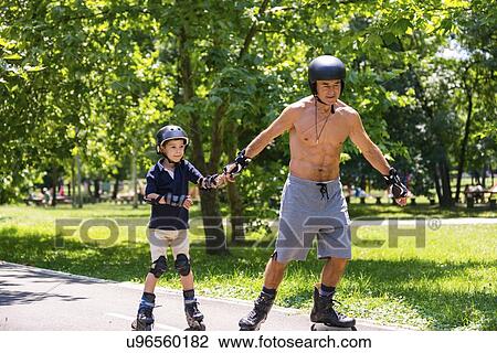 Stock Image - Grandfather teaching grandson to roller skate. Fotosearch