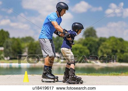 Stock Photo - Grandfather teaching grandson to roller skate. Fotosearch