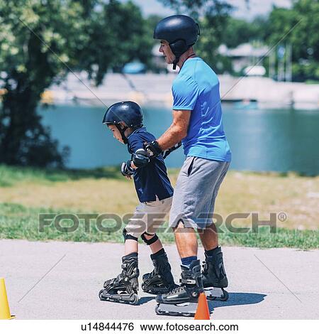 Stock Photograph - Grandfather teaching grandson to roller skate. Fotosearch