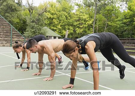 Stock Image - Group exercise class outdoors. Fotosearch