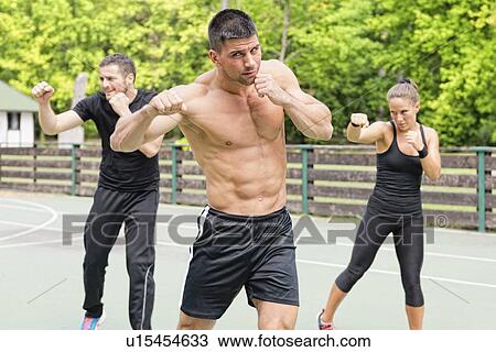 Stock Image - Group exercise class outdoors. Fotosearch
