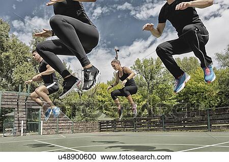 Stock Image - Group exercise class outdoors. Fotosearch