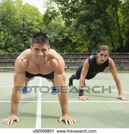 Stock Image - Group exercise class outdoors. Fotosearch