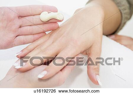Stock Photograph - Hand cream application during manicure. Fotosearch
