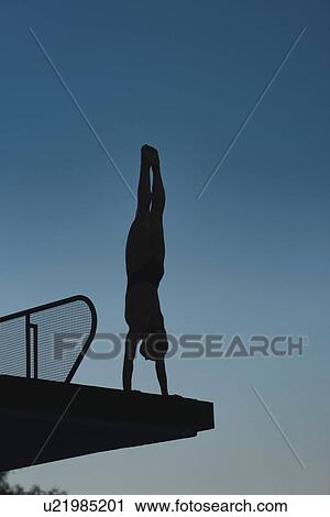 Stock Image - Handstand diver on diving platform. Fotosearch