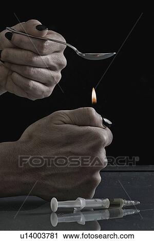 Stock Image - Heating heroin in spoon. Fotosearch
