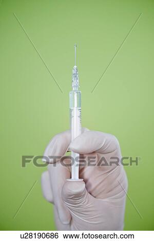 Holding filled syringe View Large Photo Image Stock Photograph - Holding filled syringe. Fotosearch