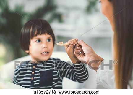 Stock Photo - Homeopath giving remedy to child. Fotosearch