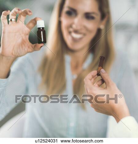 Stock Image - Homeopath giving remedy to woman. Fotosearch