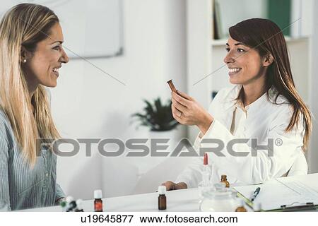 Stock Photo - Homeopath giving remedy to woman. Fotosearch