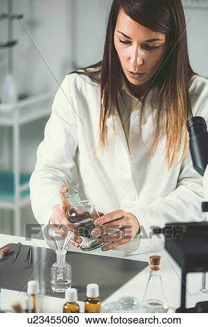Stock Image - Homeopath preparing herbal remedies. Fotosearch