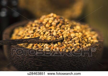 Stock Image - Honey bee pollen in wooden bowl, close up. Fotosearch