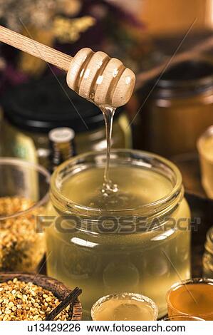 Honey flowing into a glass jar View Large Photo Image Stock Photograph - Honey flowing into a glass jar. Fotosearch