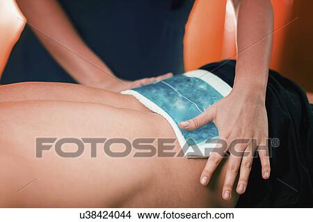Picture - Ice pack on painful lower back. Fotosearch