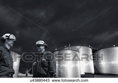 Stock Image - Industry workers and fuel storage. Fotosearch