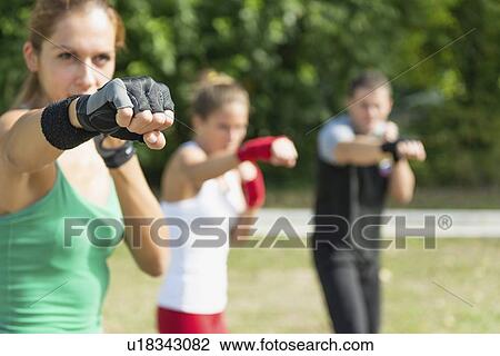 Stock Image - Kickboxing training outdoors. Fotosearch