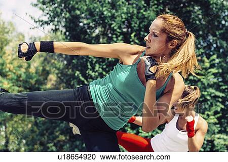 Stock Image - Kickboxing training outdoors. Fotosearch