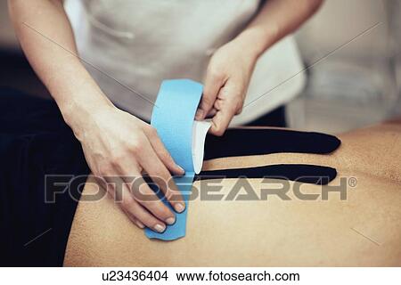 Picture - Kinesio tape application. Fotosearch