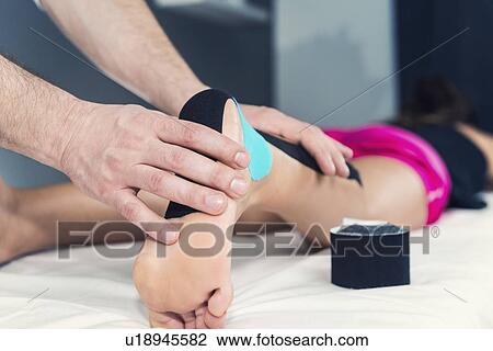Stock Image - Kinesio tape application. Fotosearch