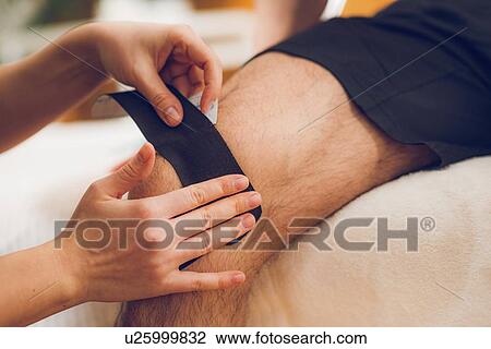 Stock Image - Kinesio tape application. Fotosearch