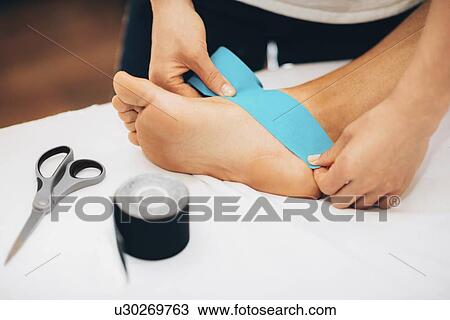 Stock Image - Kinesio tape application. Fotosearch