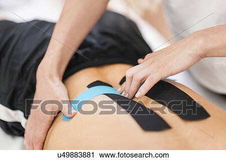 Stock Image - Kinesio tape application. Fotosearch