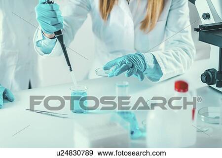 Stock Photo - Laboratory technician with micropipette. Fotosearch