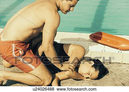 Lifeguard putting woman in recovery position View Large Photo Image Stock Photo - Lifeguard putting woman in recovery position. Fotosearch